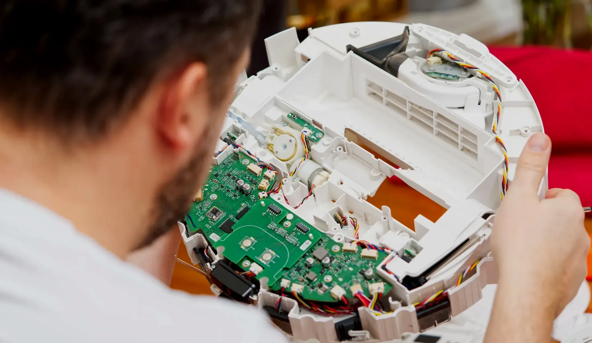 Expert examining disassembled consumer electronics for product liability forensic failure analysis
