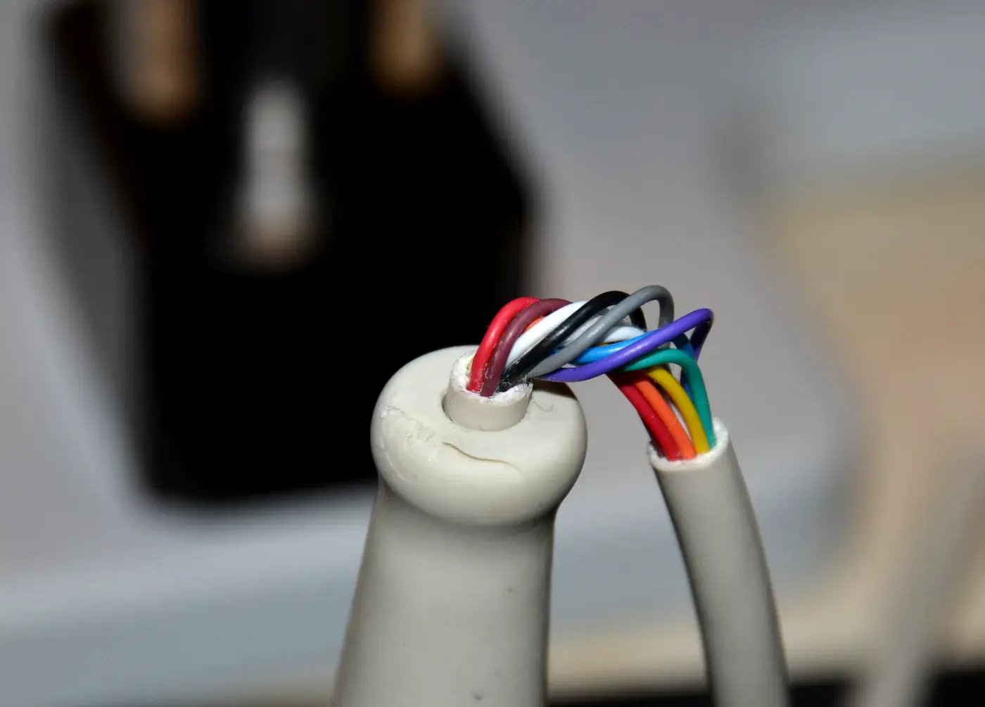 Cracked plastic cable housing on hospital diagnostic equipment exposing wires in fatigue failure analysis