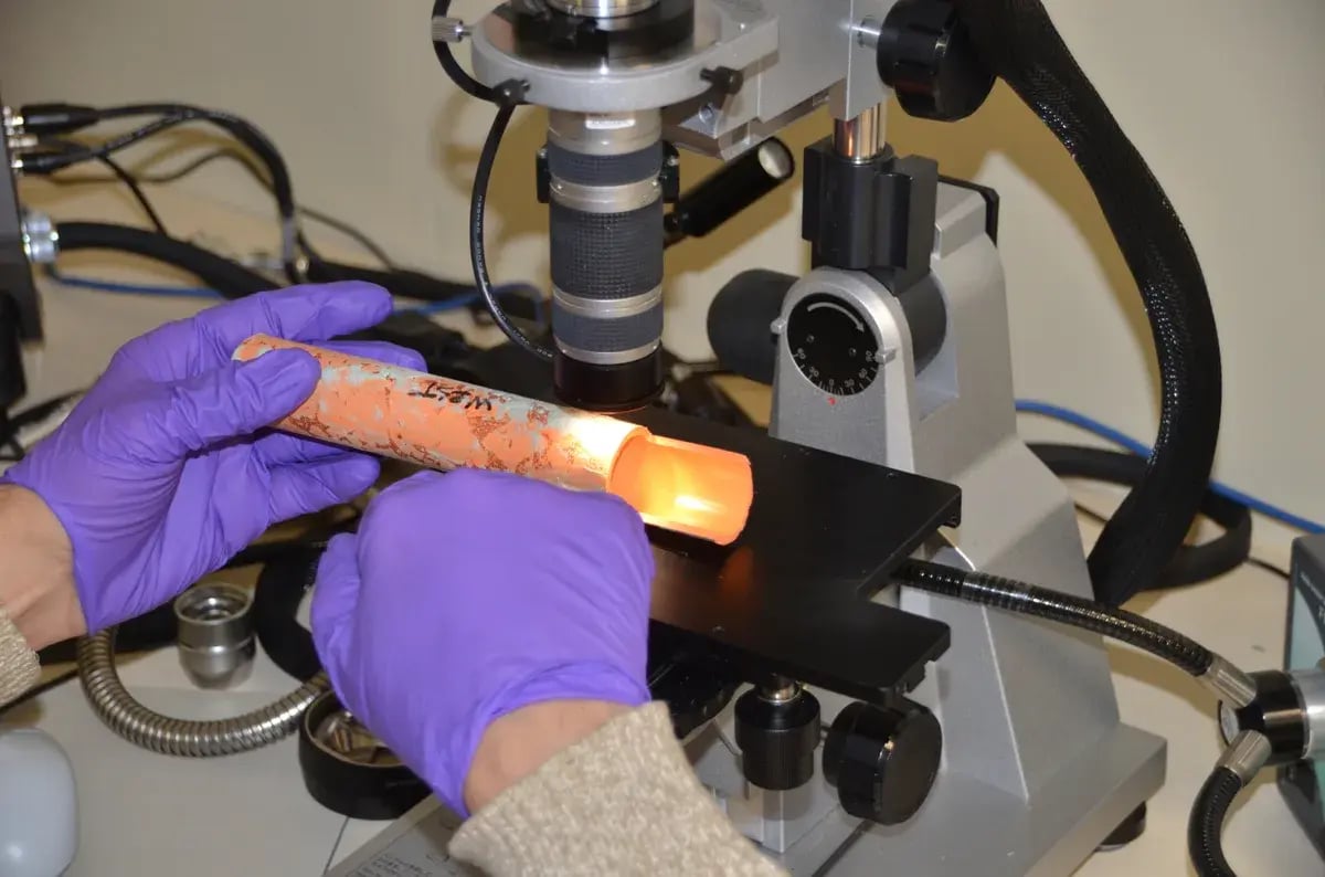 Forensic laboratory analysis of failed CPVC plastic pipe under polarized light microscope — expert witness failure investigation by Plastic Expert Group