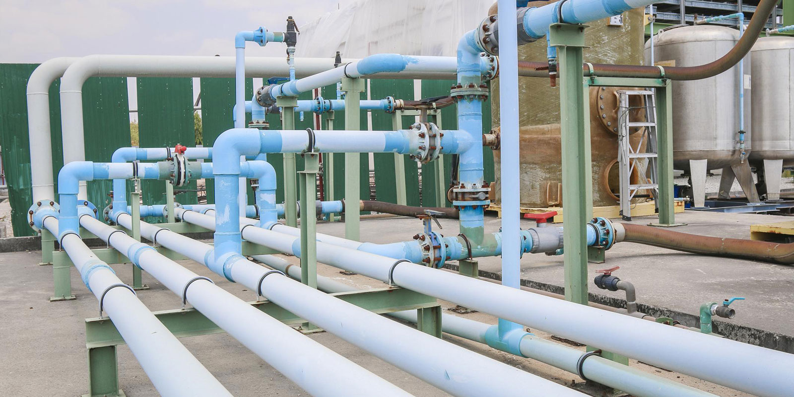 Blue and white PVC pressure piping with valves and fittings in a water treatment facility