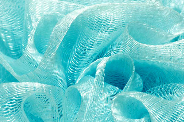 Close-up of translucent blue-green polymer surgical mesh