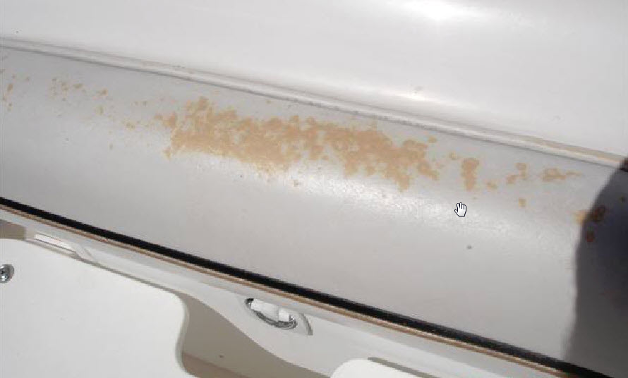 White boat vinyl upholstery with a band of mottled tan and orange discoloration across its surface